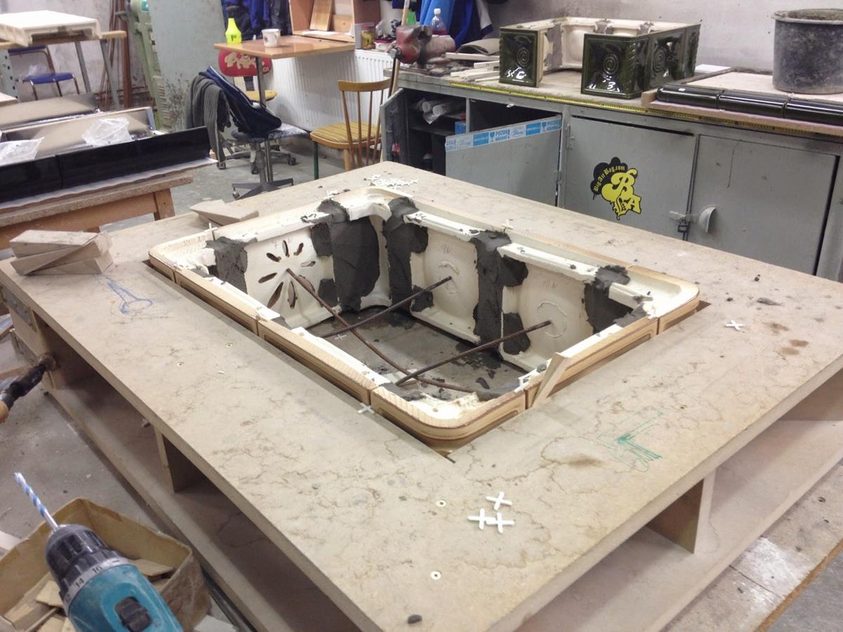 Démoulage d'une grande pièce principale du corps de chauffe d'un poêle à bois en céramique ROMOTOP